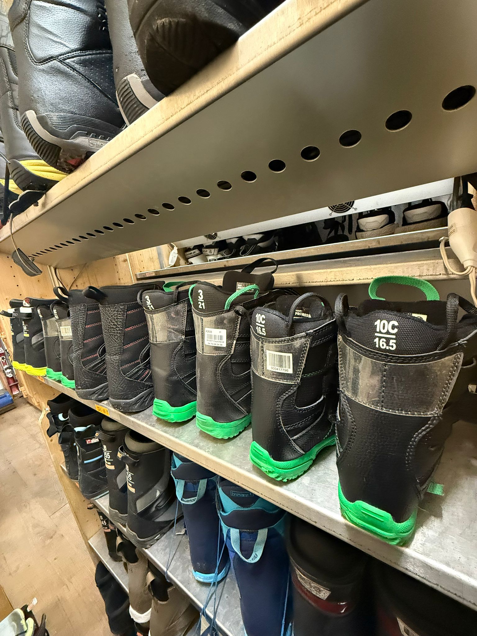 Rows of junior snowboard boots on shelves at Loca'ski