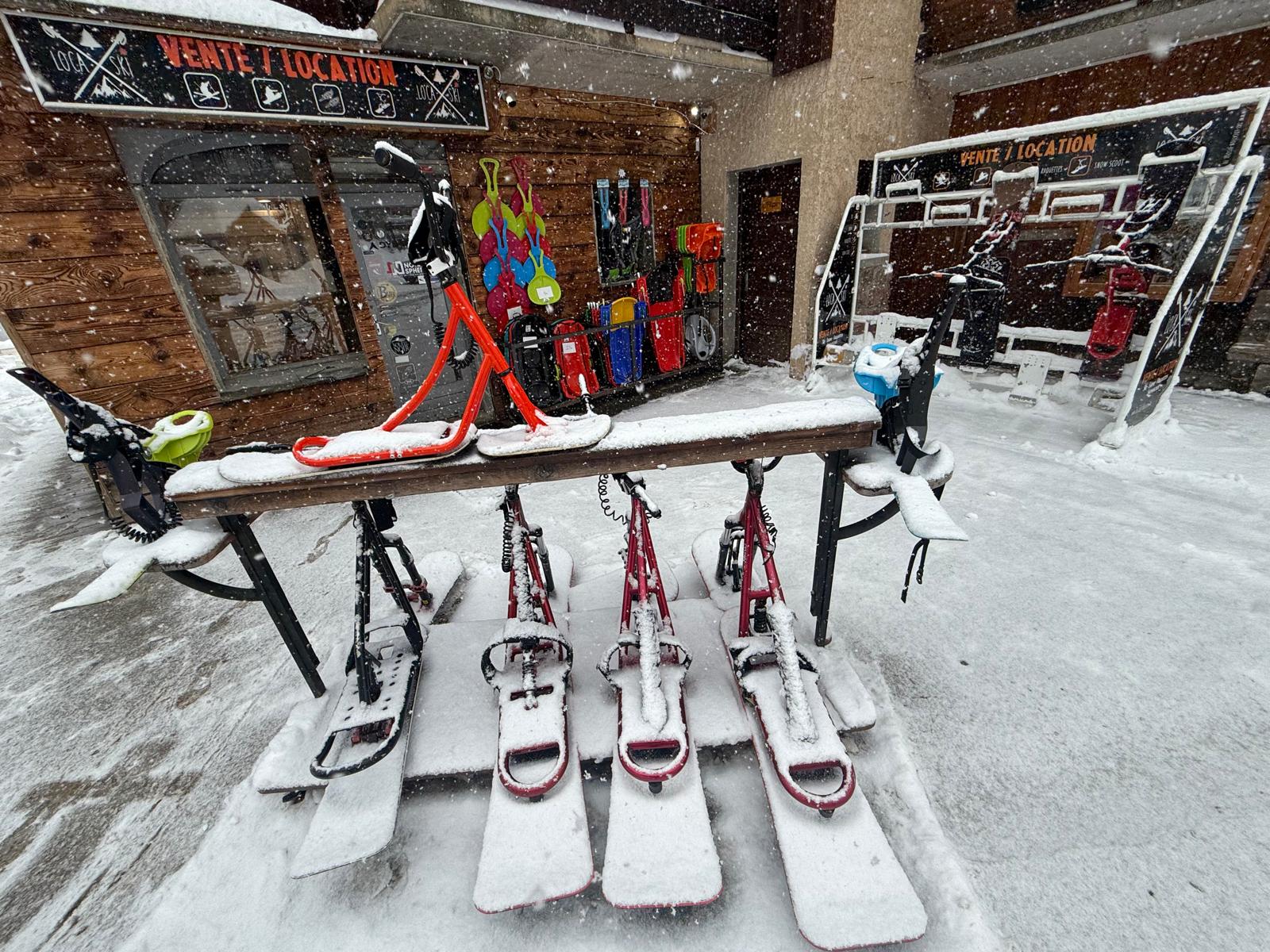 Snowy snowscoots in front of the Loca'ski shop