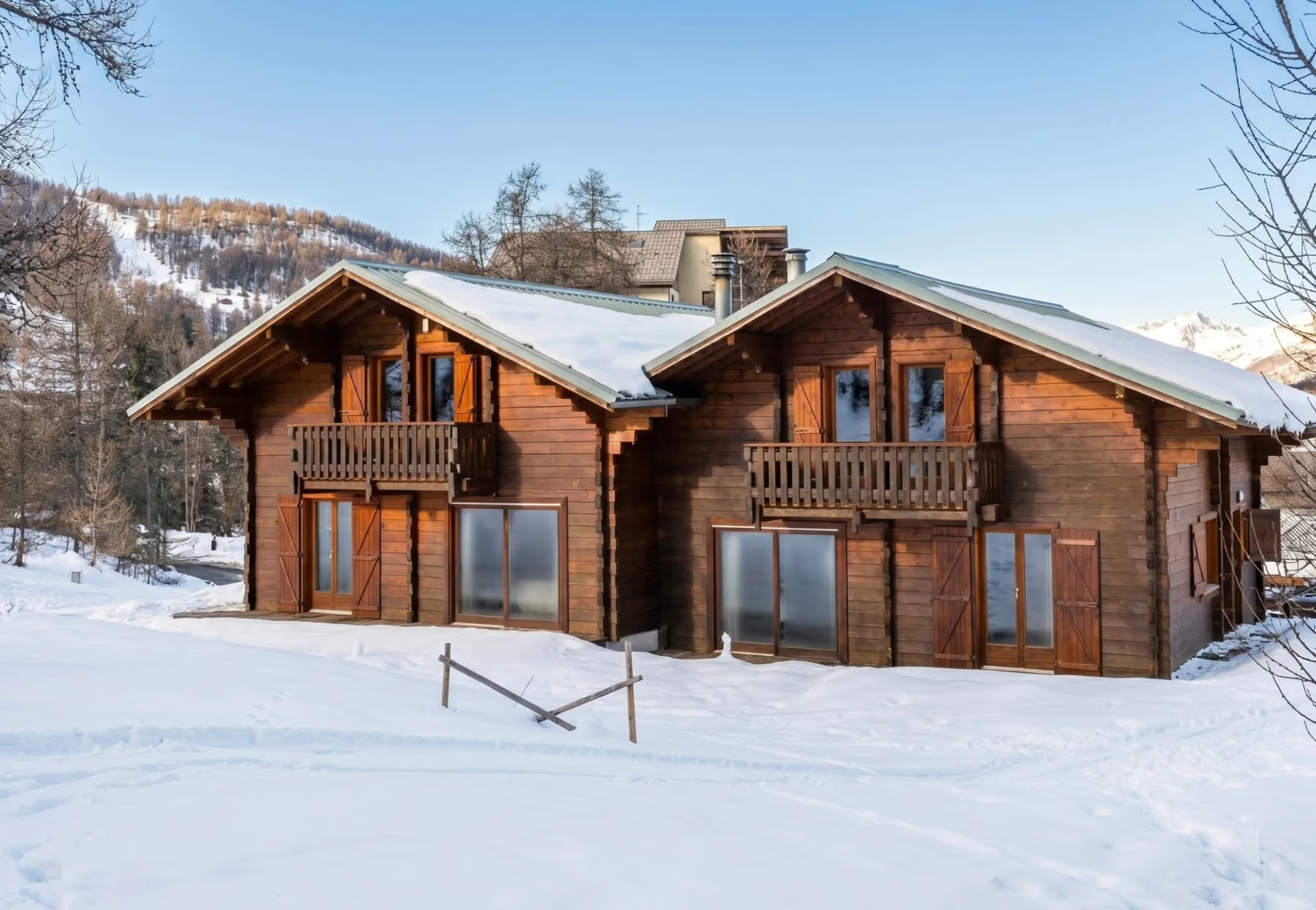 Traditional wooden chalet with balconies under a clear blue sky