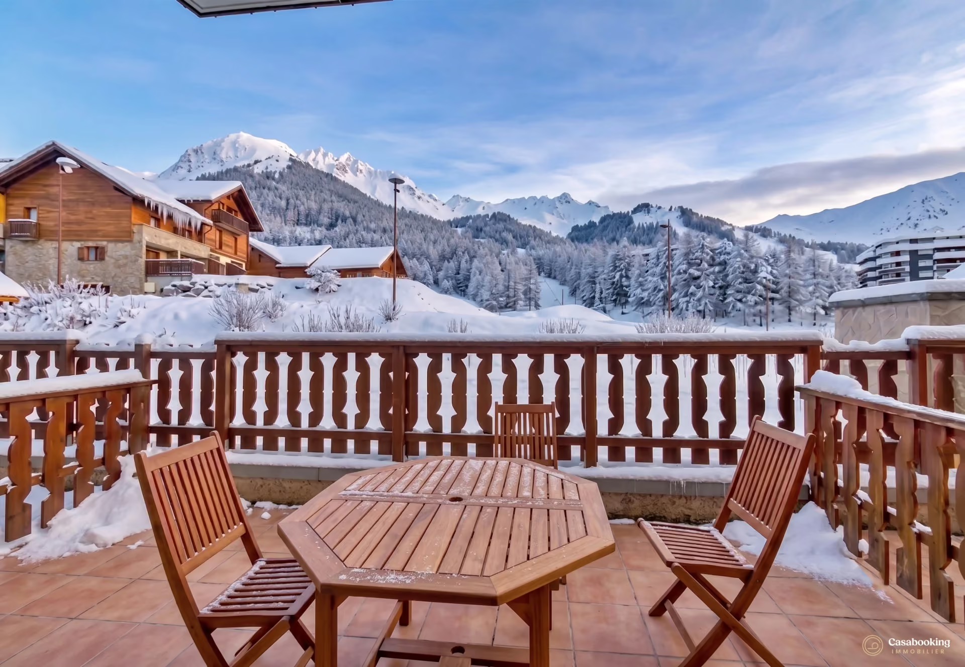 Wooden chalet terrace offering a panoramic view of the mountains